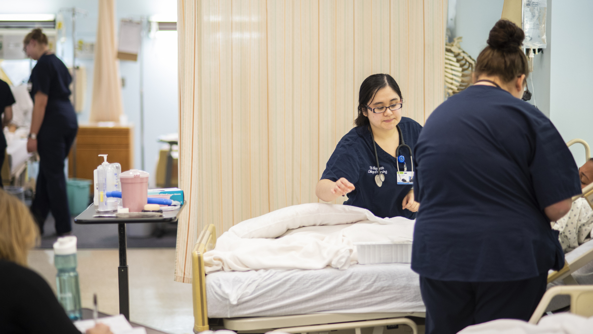 Nursing students attending to a patient.