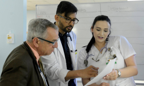 Student with doctor reviewing paperwork.